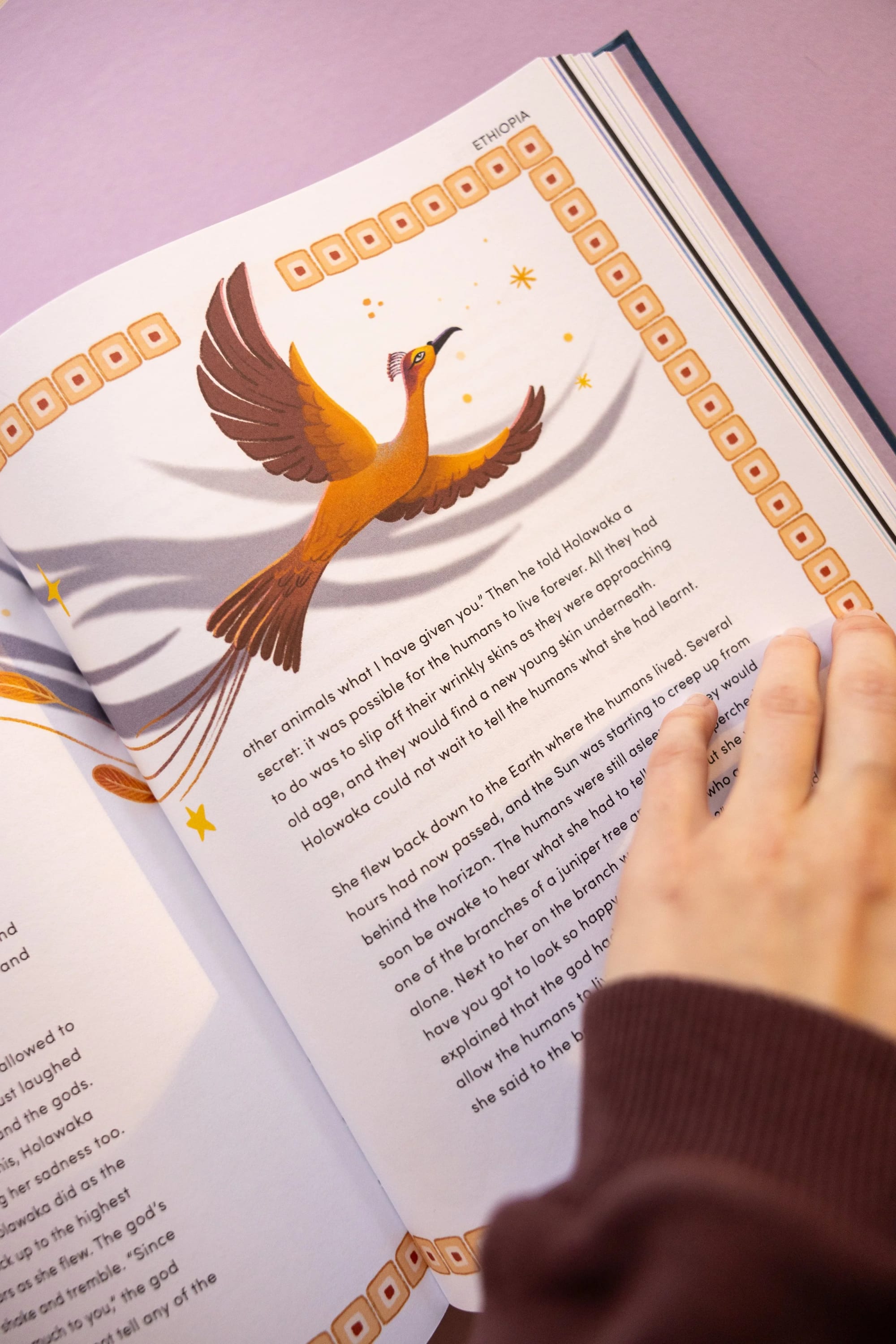 Open illustrated book pages showing text about Ethiopia and a colorful drawing of a bird with outstretched wings flying above the text.