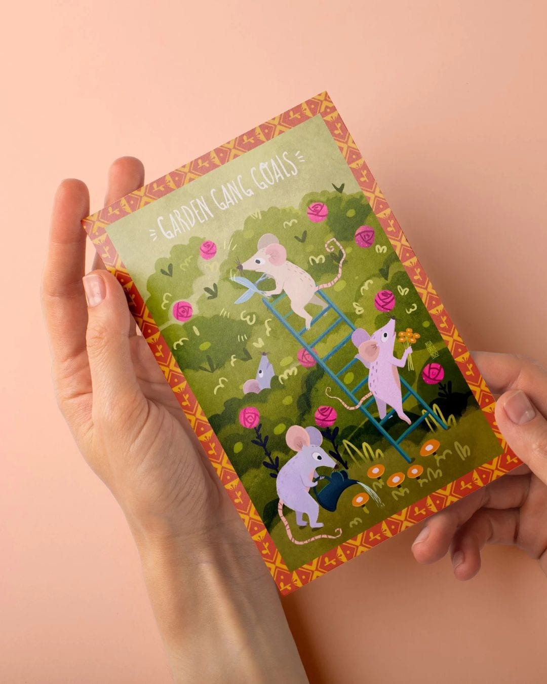Garden Gang Goals postcard held in hands, mice tending to a rose bush.