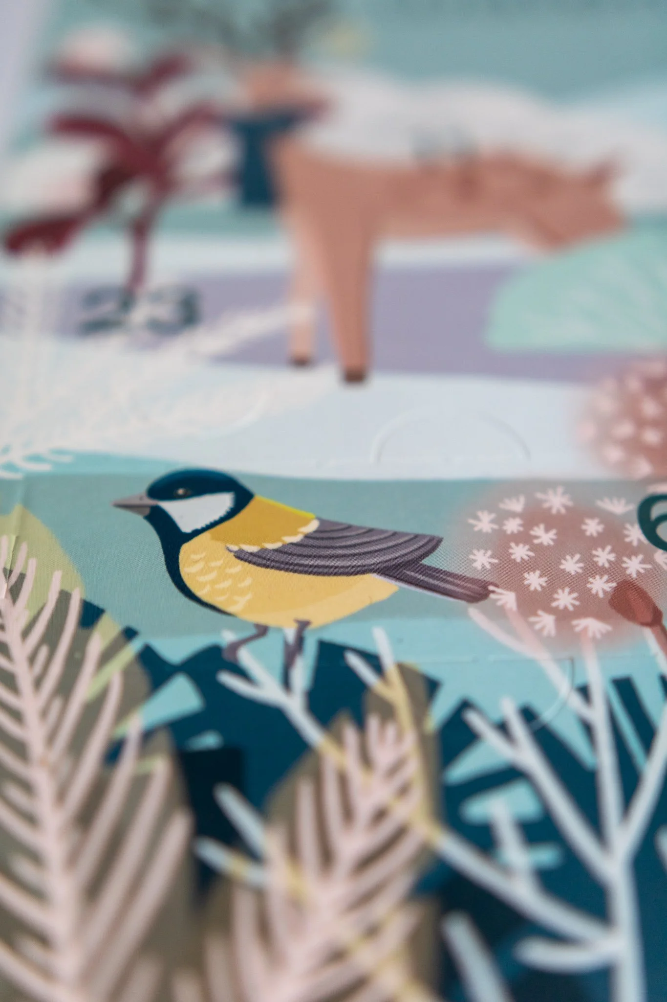 A colorful illustrated scene featuring a blue tit bird, plants, and a distant deer in a stylized, whimsical landscape.